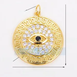 Macro view of gold evil eye pendant with Greek key pattern and cubic zirconia inlay