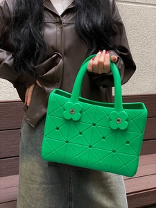 Detail der grünen EVA-Strandtasche mit geometrischer Textur und Blumen-Verschlusskappen