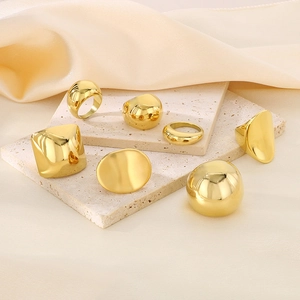 Detailed view of 7-piece 18k gold-plated geometric rings set on elegant stone display