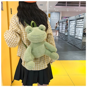 Back view of a model wearing the green plush frog backpack with adjustable straps