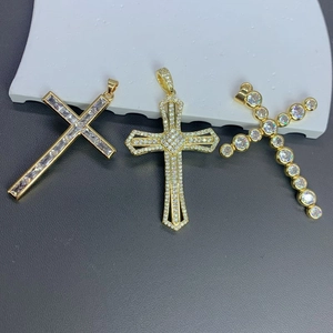 Detailed view of three gold zircon cross pendants with various crystal stone settings