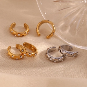 Macro shot of gold and silver C-shaped ear cuffs with sparkling white zircon stones