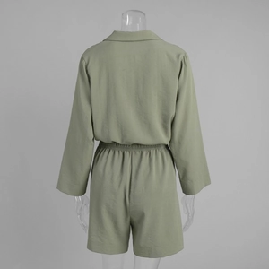Back view of grass green short jumpsuit showing elastic pleated waist and woven texture