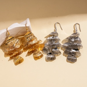 Hollow petal tassel hook earrings in gold and silver finish on a textured background