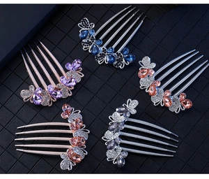 Detail of five butterfly rhinestone hair combs in blue, purple, champagne, and pink