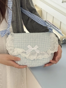 Close-up of pink and blue checkered lace crossbody bag with heart quilting and bow