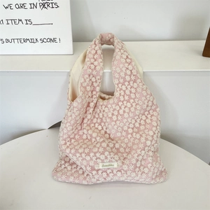 Detail einer rosa Netztasche aus Canvas mit weißen floralen Spitzenstickereien und Label