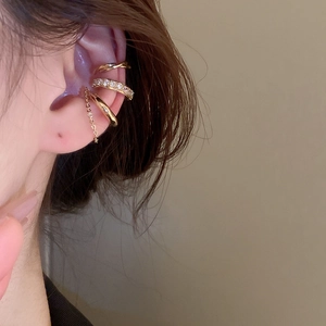 Close-up of three-piece gold ear cuff set with zircon diamonds and chain tassel detail