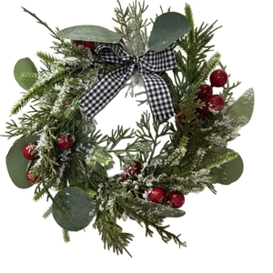 Frosted Christmas wreath with pine branches, red berries, and black-white checkered bow