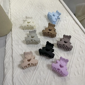 Variety of colorful matte bear hair claws with heart cutouts on white fabric