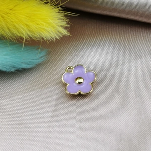 Close-up of purple five-petal flower pendant with gold edges on silk for DIY jewelry