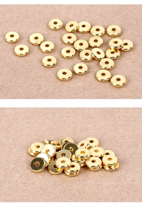 Close-up of golden flat circular spacers with center holes for bead bracelets