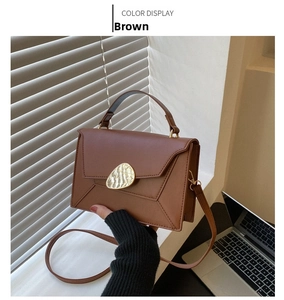 Detail view of brown PU leather handbag featuring a unique golden oval buckle decoration