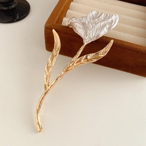 Close-up of elegant tulip brooch with white pleated petals and textured gold stem