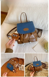 Detail view of mini drawstring backpack in blue canvas and brown faux leather with monster charm