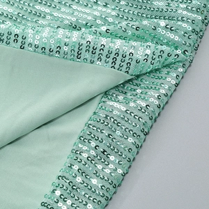 Close-up of mint green sequins and lining details on a slimming slit party dress