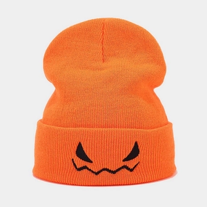 Close-up of orange Halloween beanie with black embroidered monster face and knit texture