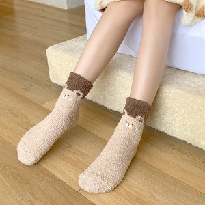 Detail of coral fleece winter socks featuring a cute 3D cartoon bear design and cozy plush texture
