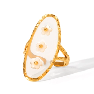 Detail of hammered gold ring featuring three white resin flowers and vintage texture