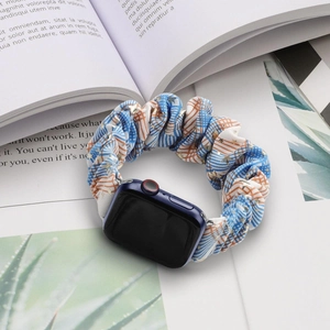 Blue and orange star pattern scrunchie strap for Apple Watch on aesthetic magazine background