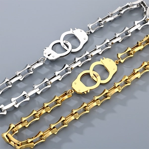 Detailed close-up of gold and silver hip hop chain bracelets with handcuff clasp design