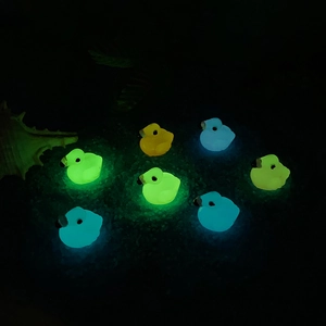 Luminous flamingo and duck resin miniatures glowing in dark blue, green, yellow