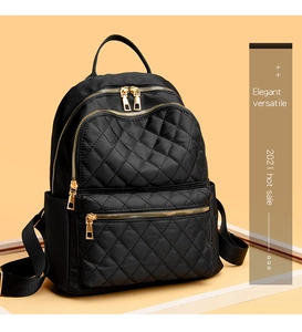 Detail of high-density black quilted nylon backpack with premium gold metal zippers
