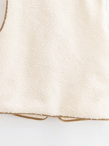 Close-up of fluffy cream faux shearling texture with brown faux suede piping details