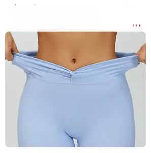 Dettaglio della vita alta incrociata e intrecciata sui pantaloncini da yoga blu