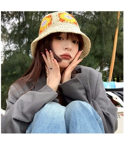 Close-up of hand-knitted bucket hat featuring colorful floral crochet patterns and texture