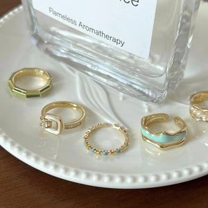 French enamel butterfly and heart open rings set in gold on a ceramic tray