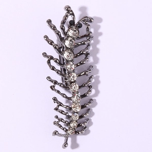 Gros plan d'une broche en forme de mille-pattes en métal gris foncé avec des strass brillants