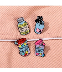 Detail showing four enamel badges with colorful bottle designs on pink fabric pocket