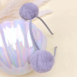Detail of soft lavender plush fur balls and grey textured headband for children's hair accessories
