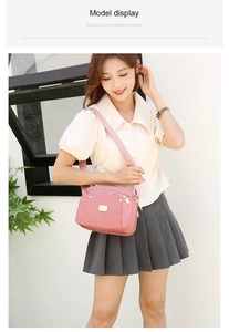 Pink nylon crossbody bag shown on a model in beige shirt and grey pleated skirt