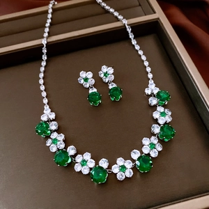 Detail of vintage flower jewelry set with green stones in a luxury brown display case