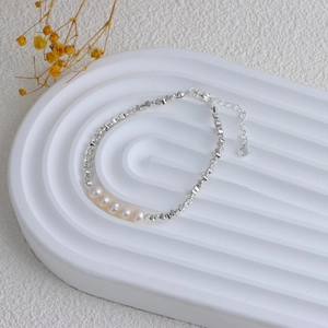 Detail view of the silver beaded bracelet with five white pearls and adjustable lobster clasp