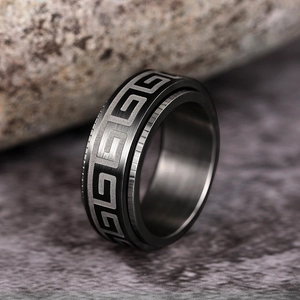 Macro detail of rotating stainless steel ring with Greek fret pattern and gear edges