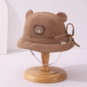Detail of brown corduroy baby bucket hat featuring 3D bear ears and chin strap
