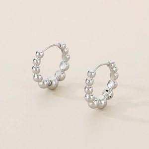 Detail shot of silver titanium steel bead hoop earrings showing beads and pin closure