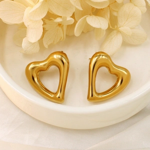 Minimalist 18K gold plated heart stud earrings displayed on a white ceramic tray
