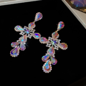 Macro shot of luxury cross drop earring with iridescent AB crystals and gold finish