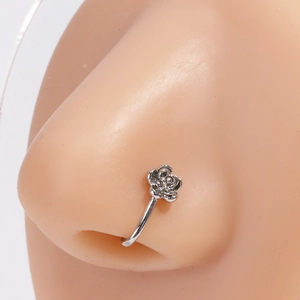 Détail d'un faux piercing nez rose argentée montrant le design floral délicat