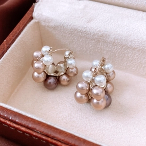Close-up of French vintage pearl C-hoop earrings displayed on a brown leather jewelry box