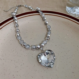 Macro shot of an elegant heart crystal pendant necklace with polished silver beads