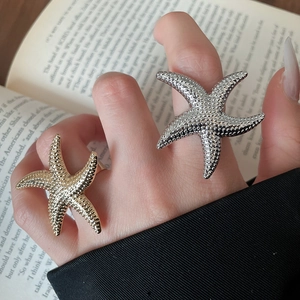 Nahaufnahme des Seestern-Rings mit strukturierter Oberfläche und Gold-Finish an der Hand