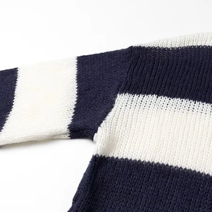 Detailed view of the navy blue and white striped knit fabric and shoulder stitching