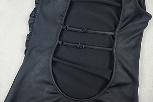 Detail of backless black maxi dress showing adjustable spaghetti straps and metal buckles