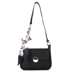 Chic black crossbody bag with polka dot scarf handle and gold hardware on white backdrop