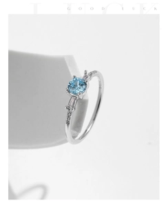 Macro shot of S925 silver ring featuring a round sky blue gemstone on geometric stand
